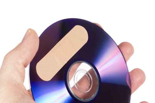A compact disk or dvd with a bandage on it. Isolated on white with clipping path.