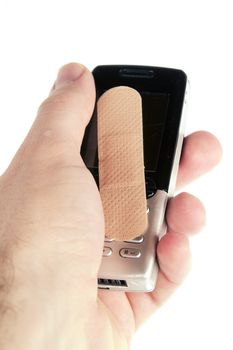 A cell phone with an adhesive bandage being held in a males hand, isolated on white with clipping path.