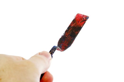 A pallet knife held in a hand.  Isolated on white with clipping path.
