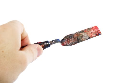 A pallet knife held in a hand.  Isolated on white with clipping path.