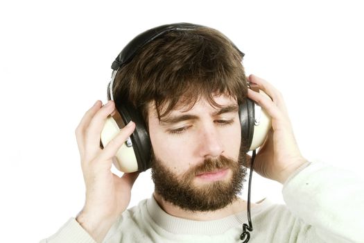 A young male with a beard listening to music on large retro headphones. Isolated on white with clipping path.
