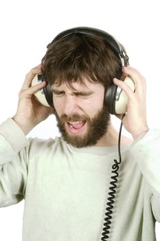 A man not enjoying what he is hearing, listening to music on large retro headphones.  Isolated on white with clipping path.