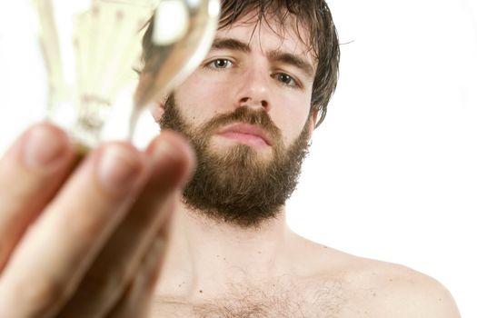 A concept image displaying a young bearded male, holding a light bulb. Fresh New Idea.
