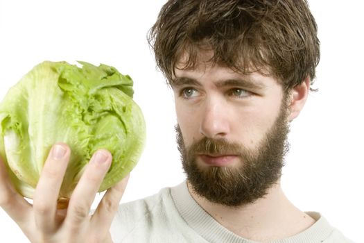 A young male with a beard looking at salad with scepticism.  The salad is out of focus.
