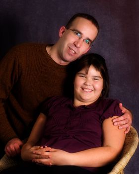 A young father and his daughter, getting their portrait done together and looking very happy