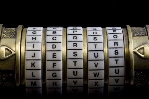 Jesus word set up as a password to combination puzzle box (cryptex) with rings of letters; black background