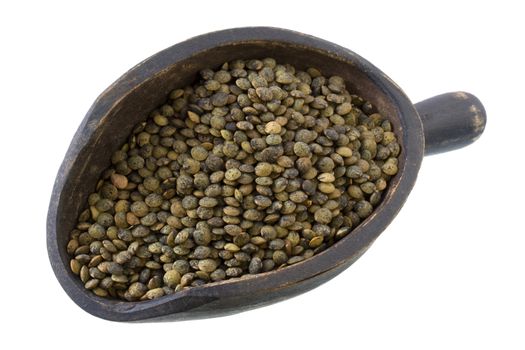 French green lentils on a primitive, wooden, dark painted scoop, isolated with  clipping path