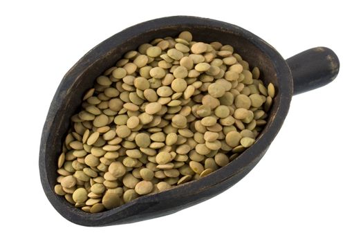green lentils on a primitive, wooden, dark painted scoop, isolated with clipping path