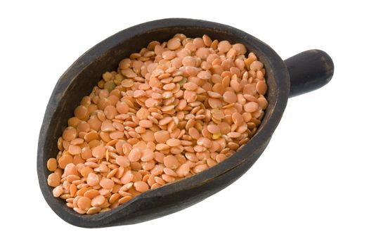 red lentils on a primitive, wooden, dark painted scoop, isolated with clipping path