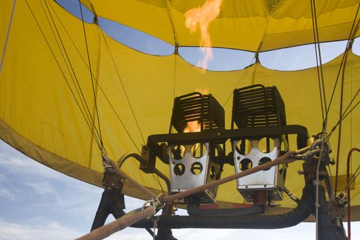 propane gas burners and flame inside a yellow hot air balloon being inflated