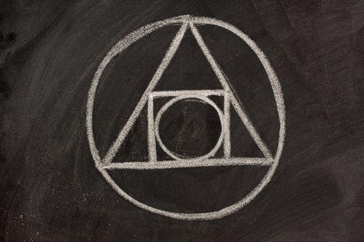 17th century alchemy symbol sketched with white chalk on a blackboard - the blending of geometric shapes, elemental symbols and astrological signs