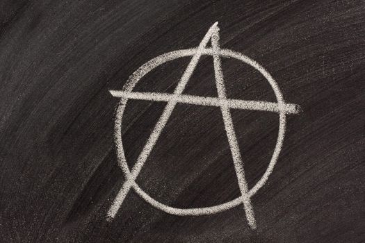 symbol for anarchy sketched with white chalk on a blackboard