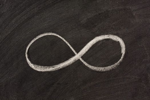 infinity sketched with white chalk on blackboard - mathematical sign, and also symbol of perfection, dualism, and unity between male and female in ancient India and Tibet