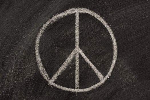 peace symbol or Nero's cross sketched with white chalk on a blackboard