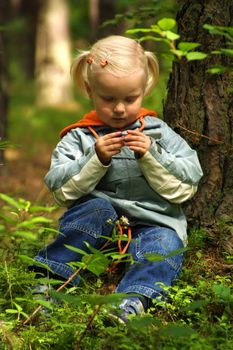 little girl is sitting in the forest