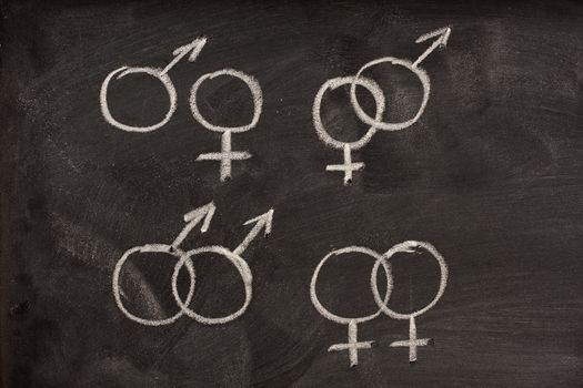 different combinations of male and female gender symbols drawn with a white chalk on a blackboard