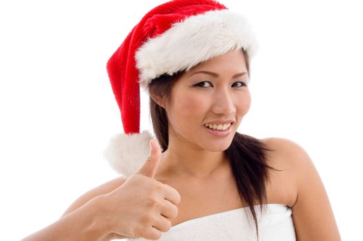 young woman with christmas hat showing thumb up on an isolated background