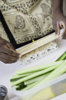 an african sushi checf in action preparing a sushi dish