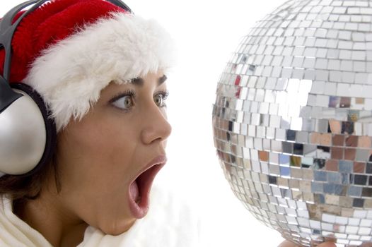 surprised woman looking to disco ball and wearing christmas hat on an isolated background