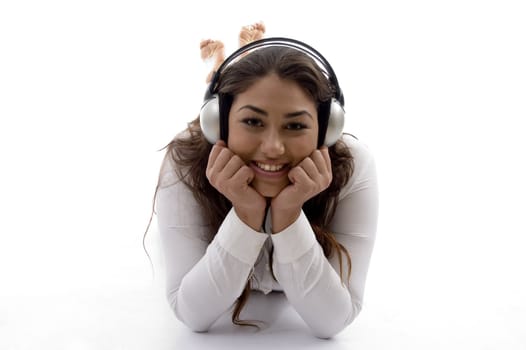 young female lying and enjoying music with white background