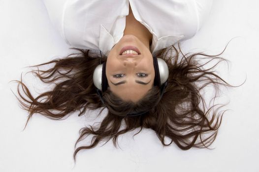 young female lying and enjoying music with white background