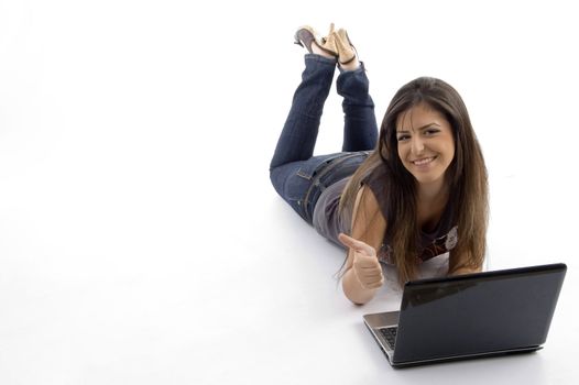 young female lying down and working on laptop  against white background