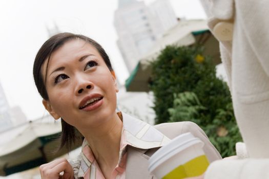 Two business women having a casual meeting or discussion in the city.  Shallow depth of field.