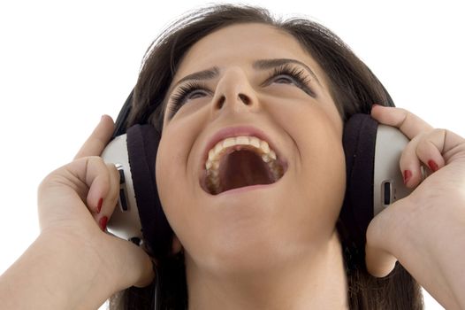 young woman listening music in headset on an isolated background