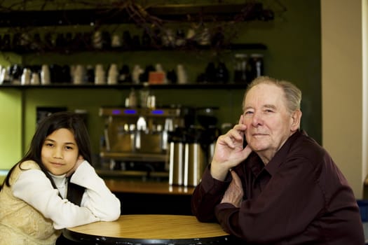 Elderly man and granddaughter at coffee shop restaurant together