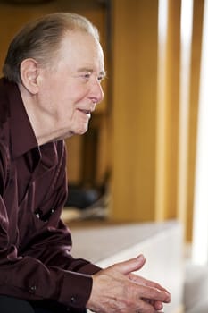 Elderly man sitting in dark church