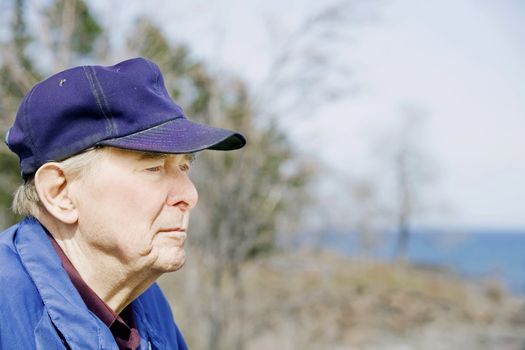 Elderly man looking out over lake