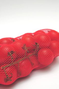 Small tomatoes in a plastic mesh bag