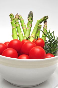 Cherry Tomatoes and Asparagus in a light colored bowl with thyme