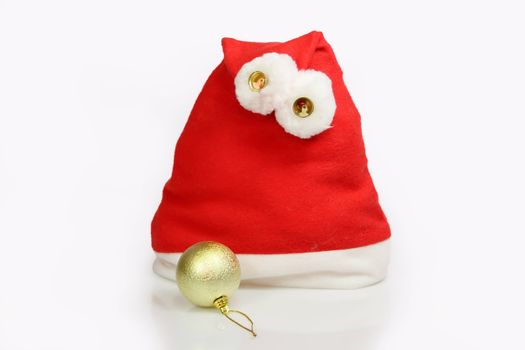Santa Claus hat with golden christmas tree ball on light background