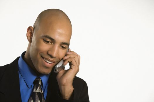 Head and shoulder portrait of African American man in suit talking on cellphone.