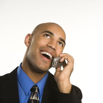 Head and shoulder portrait of African American man in suit talking on cellphone.