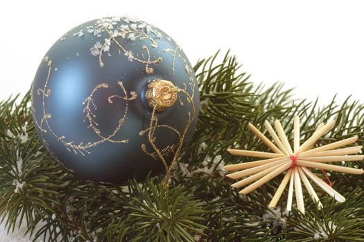 Blue christmas tree ball lying on a fir branch