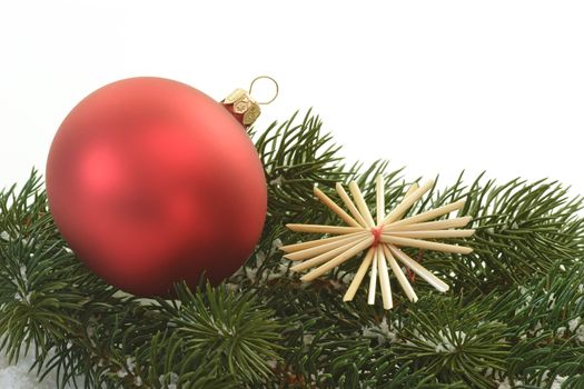 Red christmas tree ball lying on a fir branch