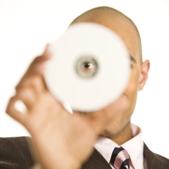 African American man holding compact disc over face and peeking through hole.