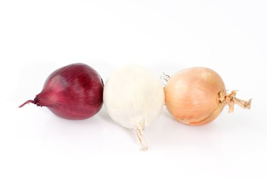 Three different colored onions on white background