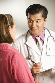 Asian American male doctor consulting with Caucasian woman.