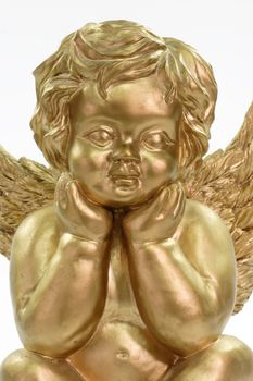Close up of a golden angel figurine on bright background