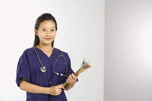Portrait of Asian Chinese mid-adult female doctor smiling and looking at viewer.