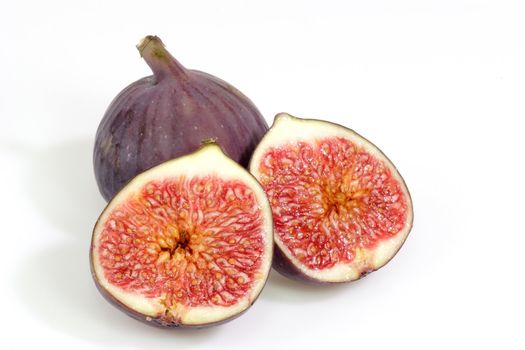 Whole and halved fig on bright background