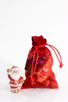 Red santa sack with santa figurine on bright background
