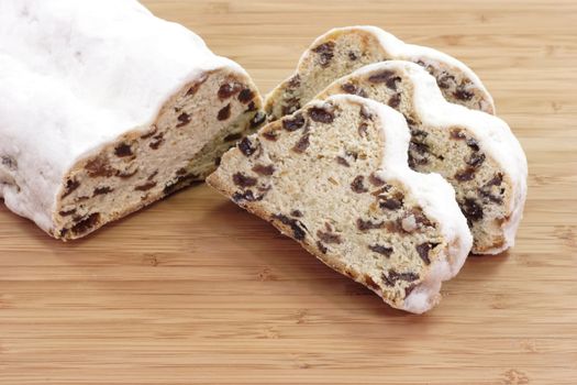 Sliced christmas stollen on a wooden kitchen board