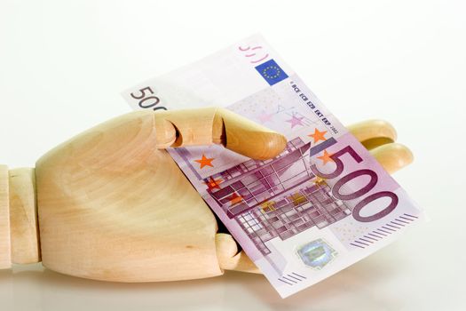 Wooden hand holding a 500 Euro bill on white background
