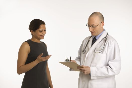 Caucasian mid adult male physician talking with Indian woman patient.