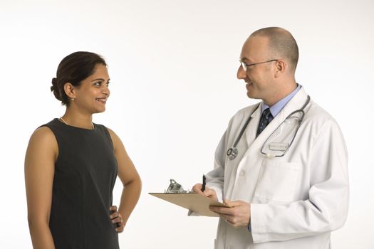 Caucasian mid adult male physician talking with Indian woman patient.