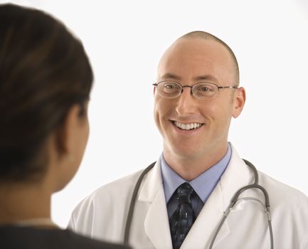 Caucasian mid adult male physician talking with Indian woman patient.